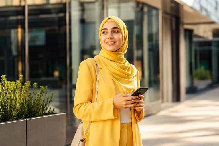 A Bolt Affiliate using her phone outside a modern office